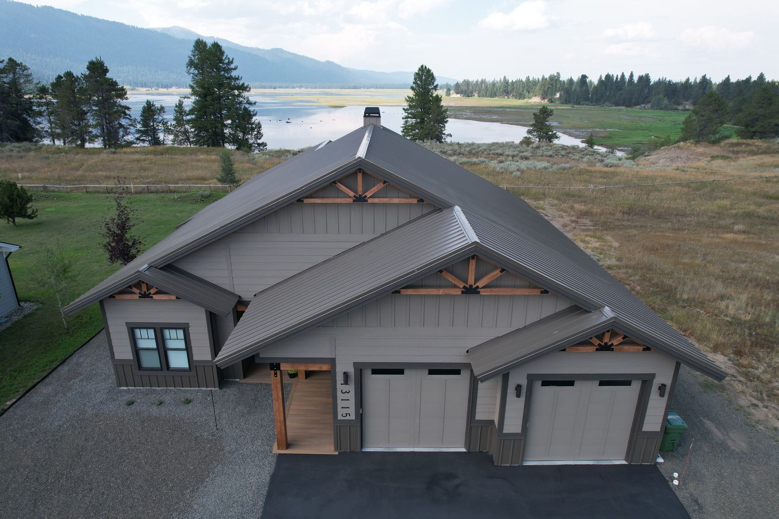 Front view of a home with a bronze standing seam metal roof near the water in Donnelly, Idaho, installed by Bork Roofing.