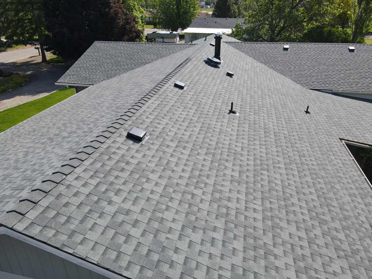 Finished light gray asphalt shingle roof with ridge caps and vents on a house in Emmett, installed by Bork Roofing.