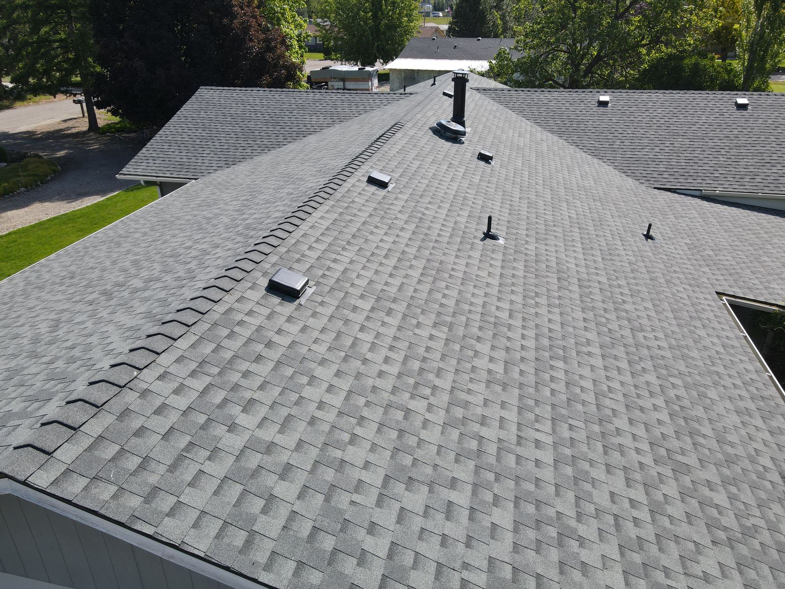 Finished light gray asphalt shingle roof with ridge caps and vents on a house in Emmett, installed by Bork Roofing.