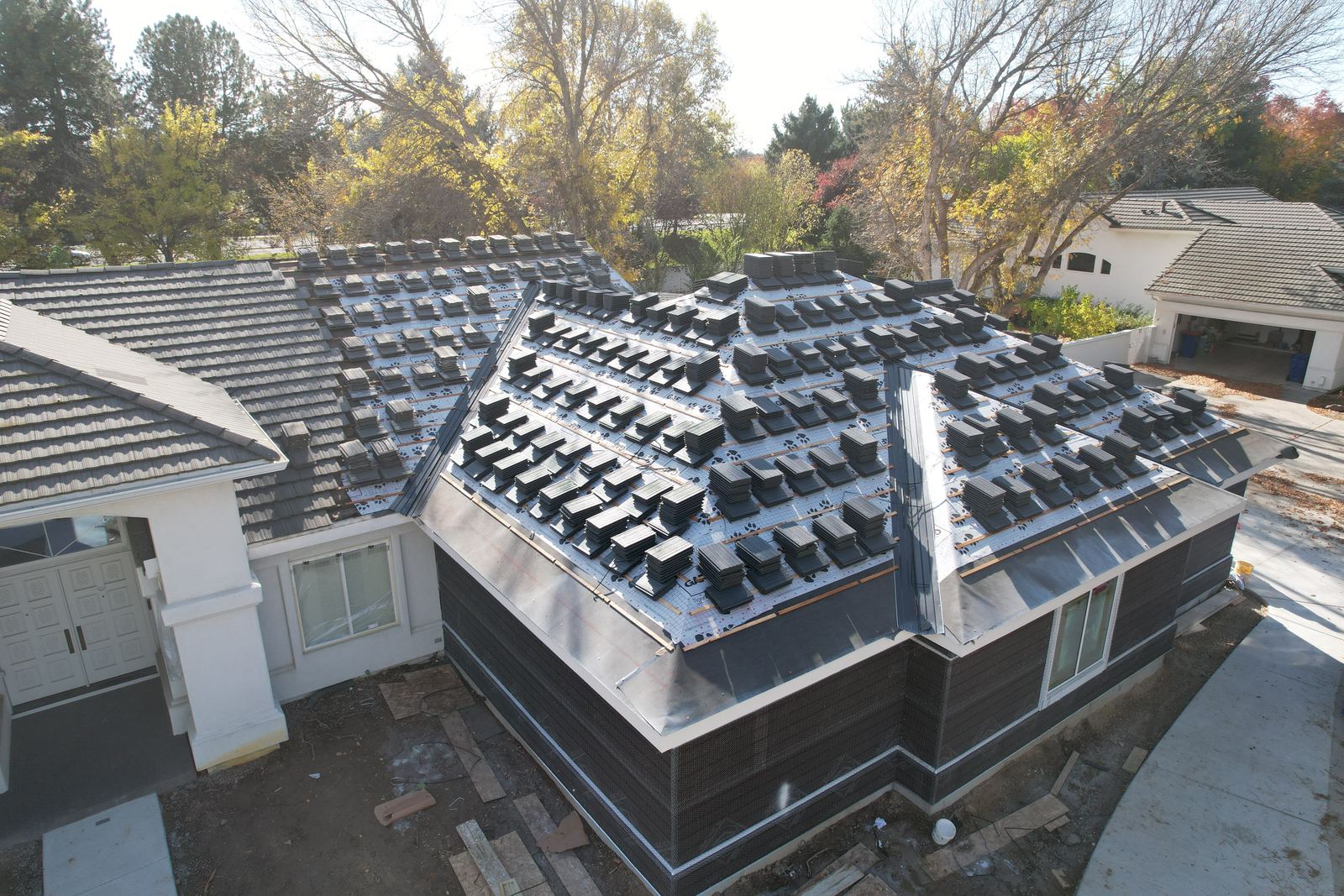 New tile stacked on synthetic underlayment and battens during a roof replacement on a Meridian home.