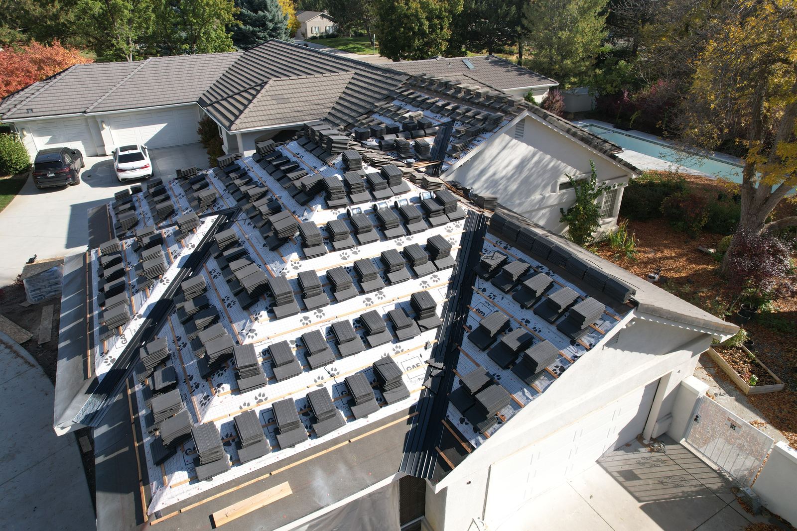 Stacks of new tile loaded on a Meridian roof deck with underlayment and battens down before install.