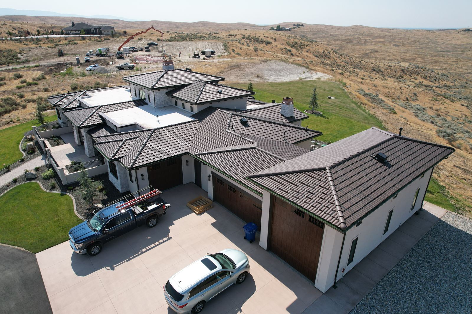 Drone view of a large Star home with a brown concrete tile roof and flat membrane sections, installed by Bork Roofing.