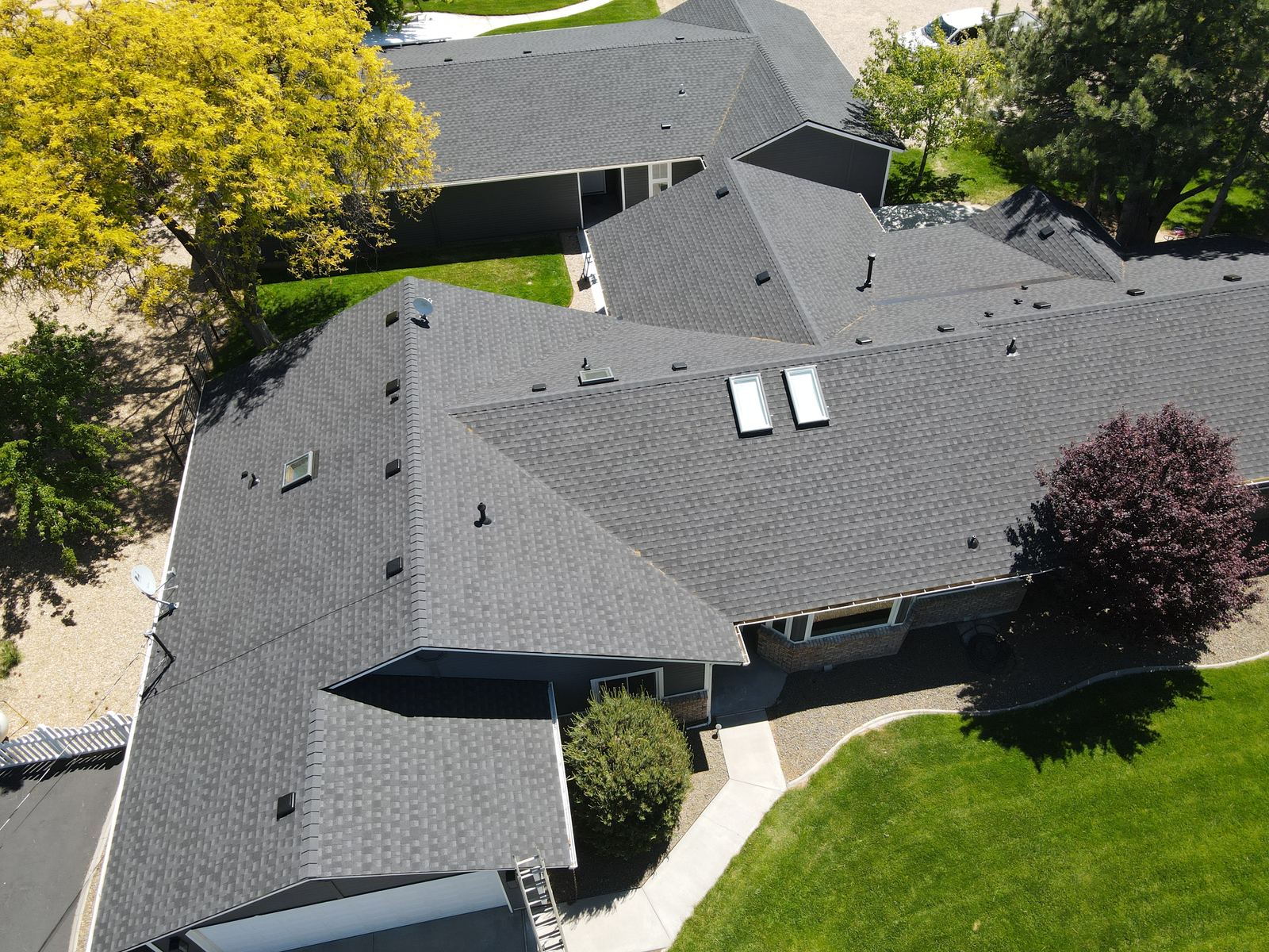 Aerial view of a dark gray asphalt shingle roof with two skylights on a single story home in Eagle, Idaho, installed by Bork Roofing.