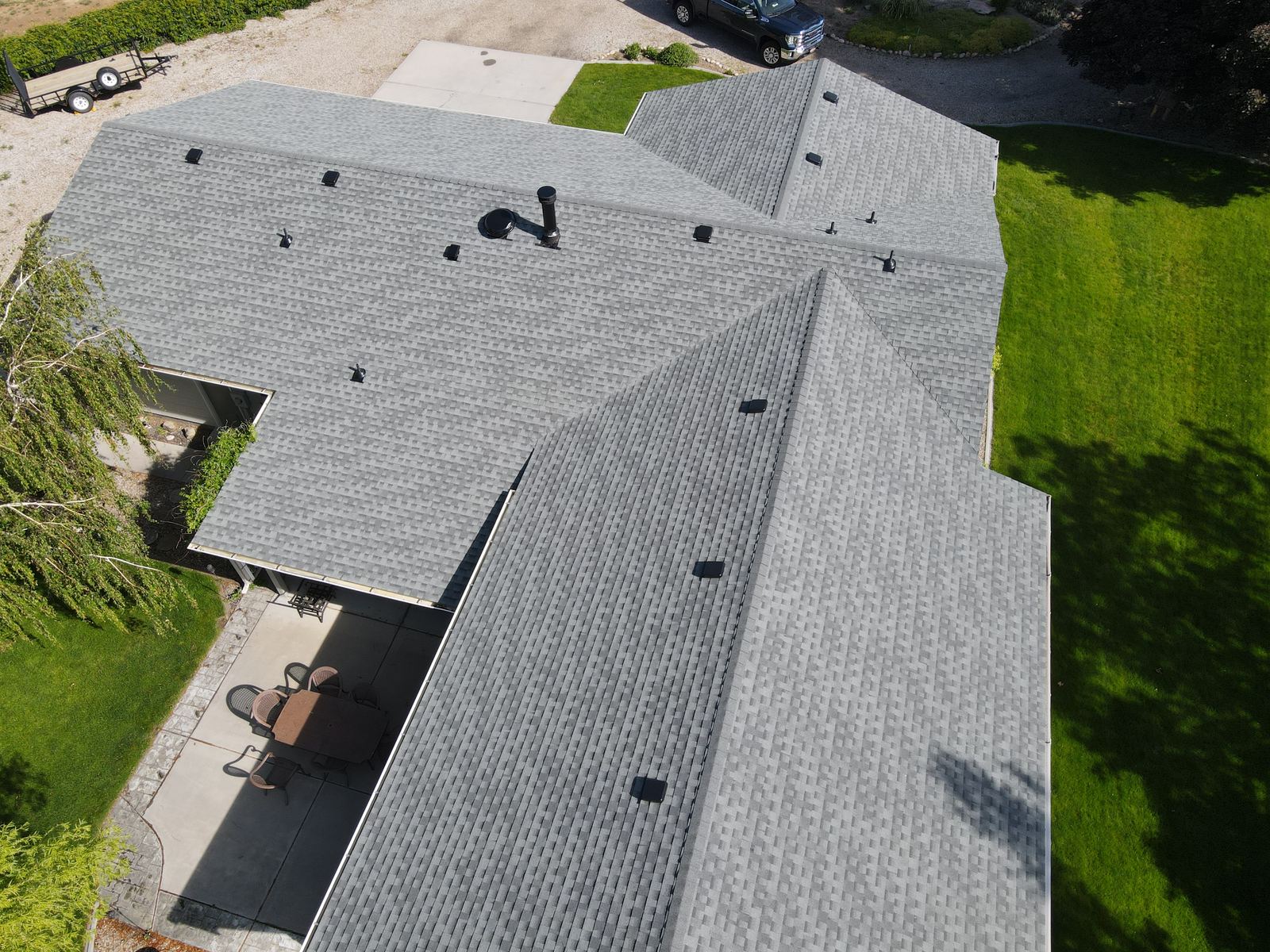 Aerial view of a light gray asphalt shingle roof over a covered patio on a home in Emmett, Idaho, installed by Bork Roofing.