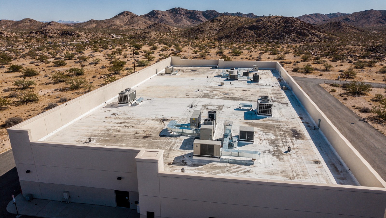 Single story commercial building roof plane with parapet walls and rooftop units